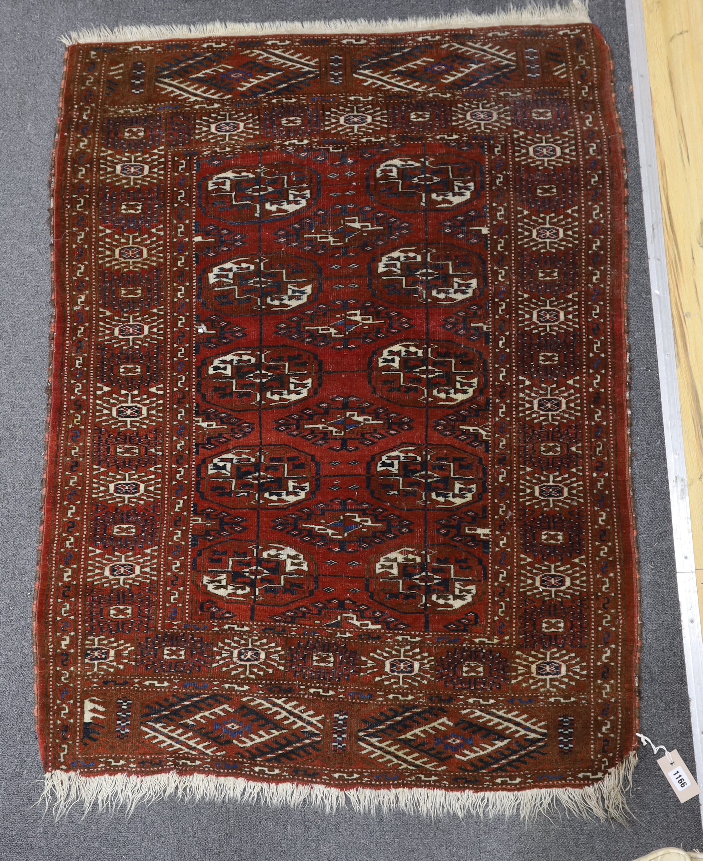 A Turkeman burgundy ground rug, 126 x 94cm